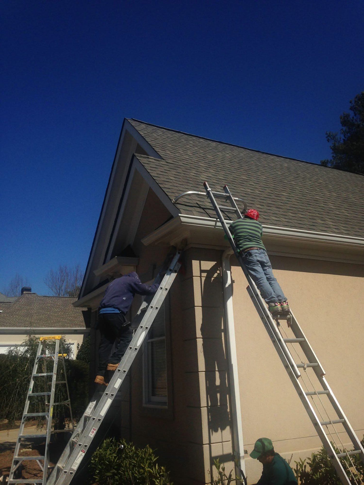 Total Choice Roofing crew working a roof edge from a ladder near Suwanee, GA